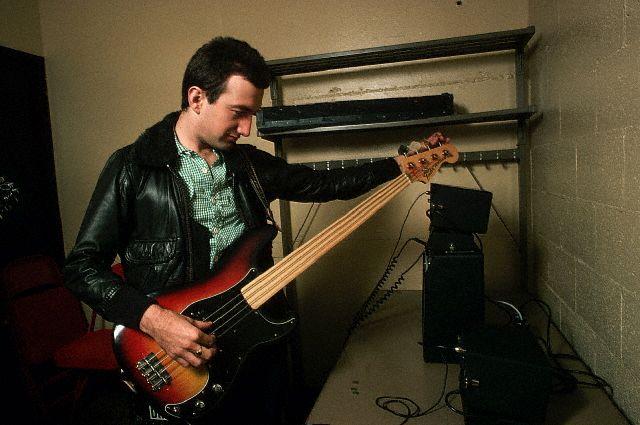 John deacon turing his bass guitar 